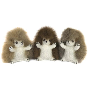 Three plush hedgehogs in a row on a white background