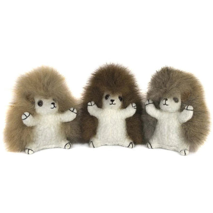 Three plush hedgehogs in a row on a white background