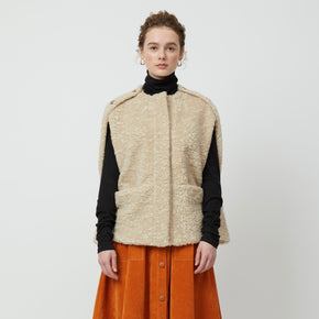 Atelier Delphine Bea Vest - model wearing light beige vest with front pockets and buttons on shoulders and sides on neutral background