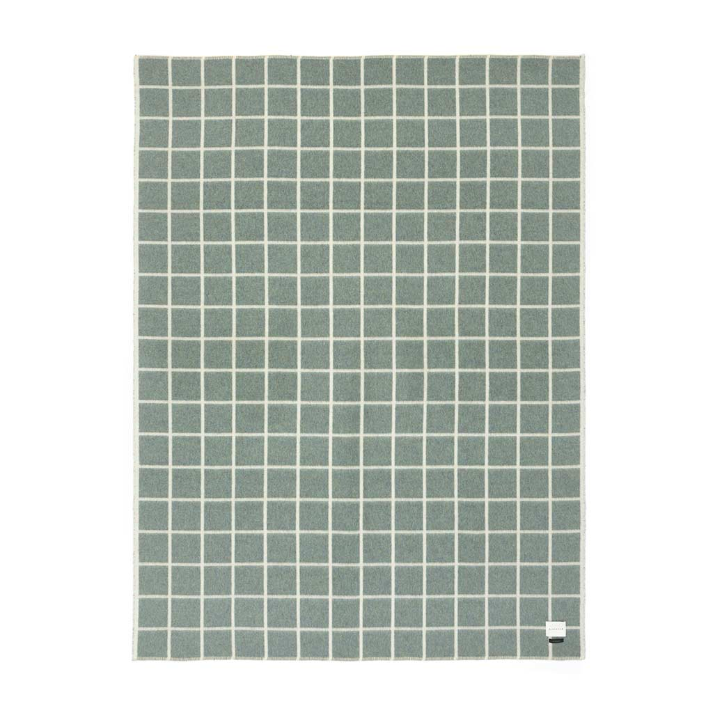 Green square patterned blanket on a white background