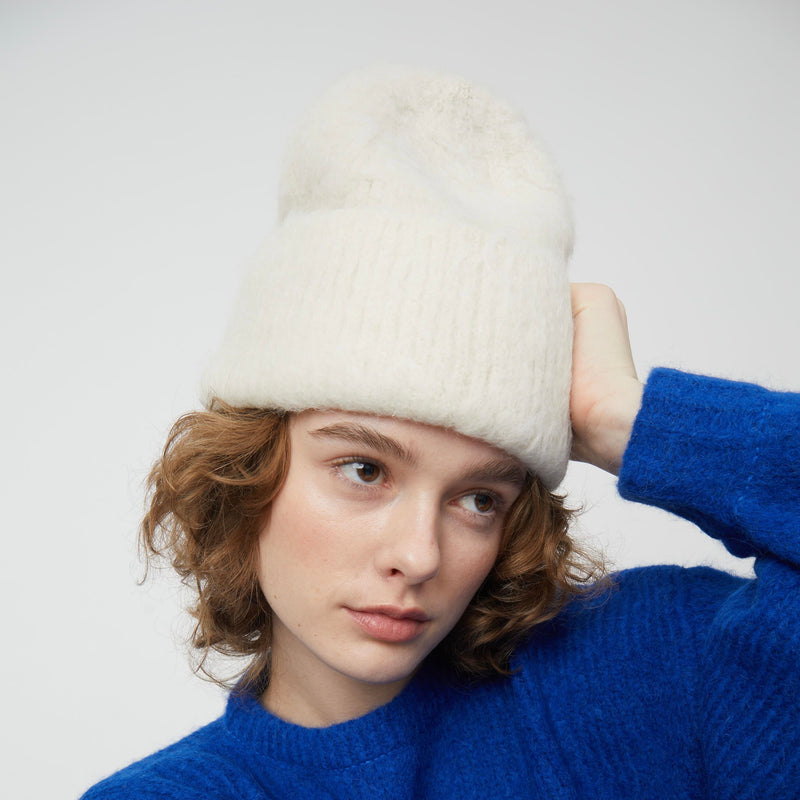 Atelier Delphine Brushed Beanie - model wearing cream colored beanie with ribbed cuff on neutral background