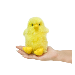 Small yellow plush chick held in a hand against a white background