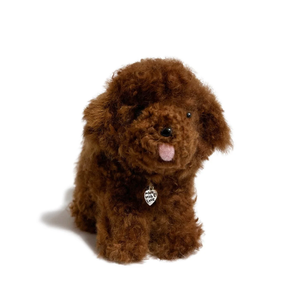 Brown plush dog toy with a tag on a white background