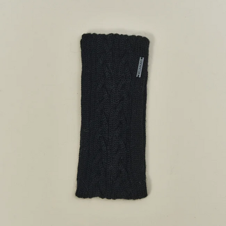 Black knitted headband with a brand tag on a beige background