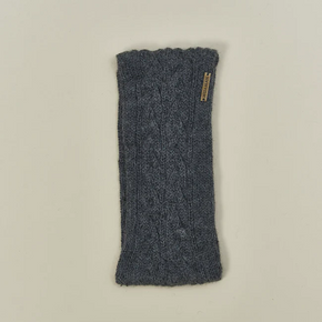 Grey knitted headband with a brand label on a beige background