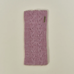 Pink knitted headband with cable pattern on a beige background