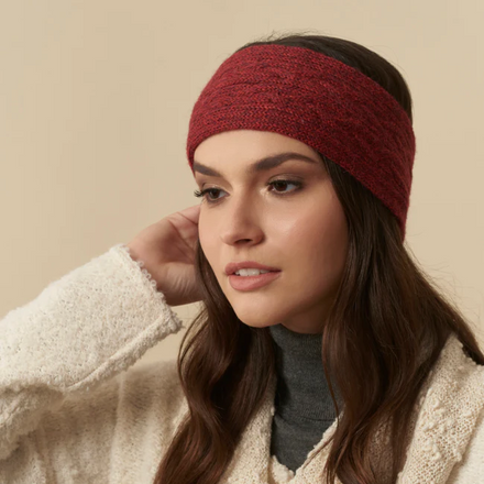 Woman wearing a red headband and beige scarf against a beige background