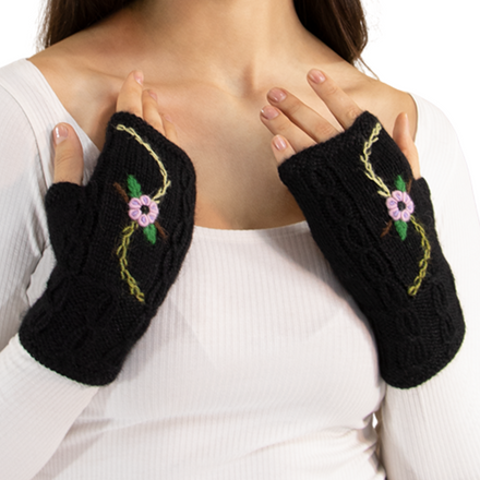 Black fingerless gloves with floral embroidery worn by a person on a white background
