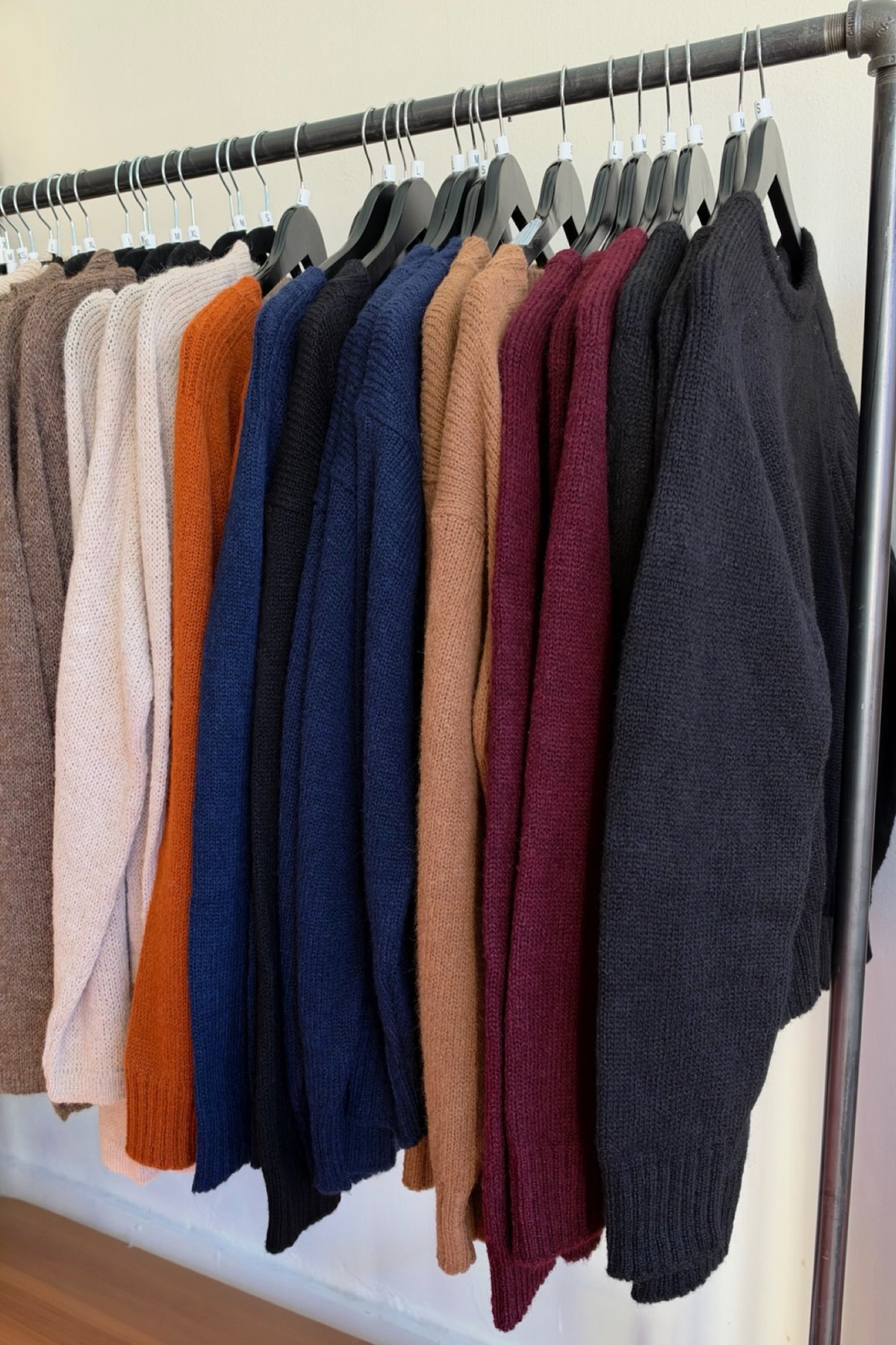 Fluff women’s sweaters in several colors on a clothing rack