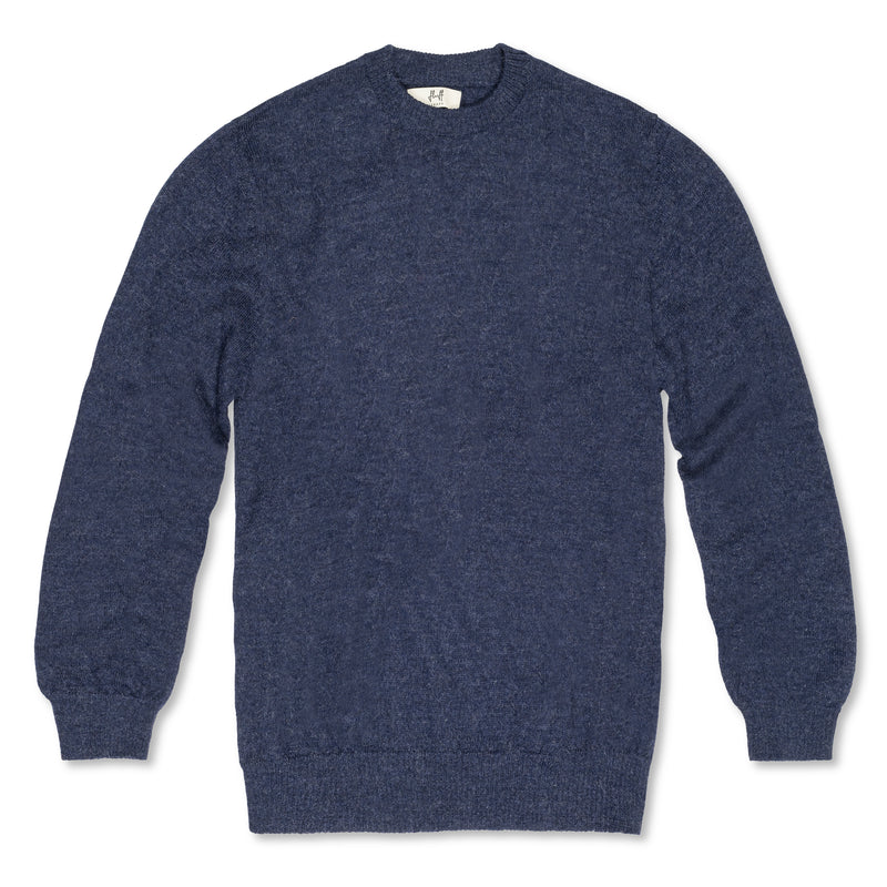 Men's Classic Crewneck 100% Baby Alpaca Sweater. A blue 100% baby alpaca crewneck sweater lying flat on a white background. 