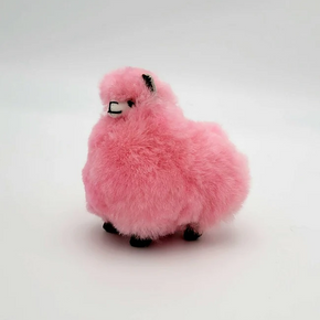 A plush pink alpaca keychain on a neutral background.