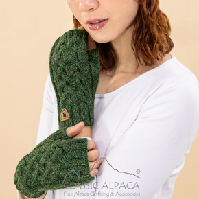 Woman wearing green knitted gloves with visible brand logo on a beige background