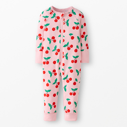 Pink zip up baby onesie with a cherry print on a neutral background.