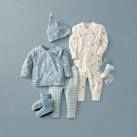 Baby clothing set with outfit, hat, and socks on a blue background