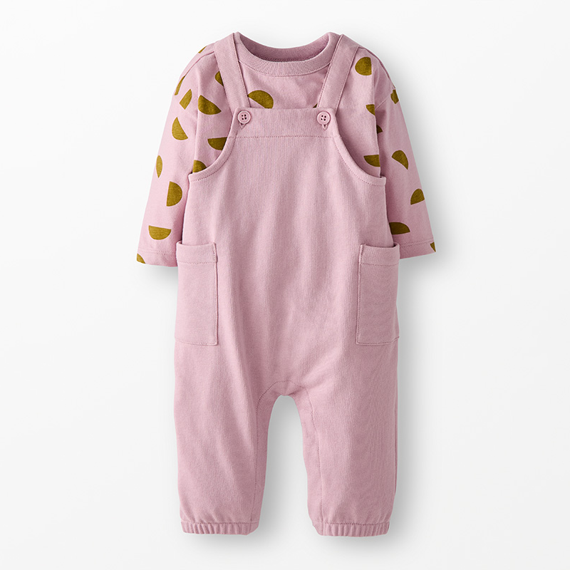 Long-sleeved baby tee in pinkish-purple with a half moon pattern and matching overalls on a neutral background. 