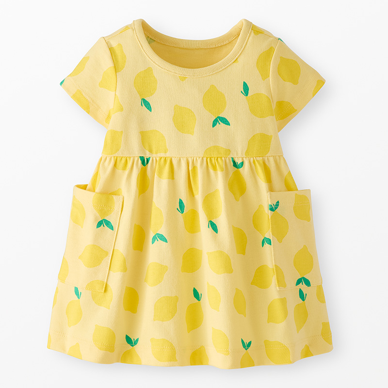 A yellow dress with a bright lemon pattern against a neutral background.