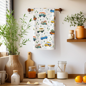 Decorative towel with vehicle pattern hanging on a wooden rack in a kitchen setting.
