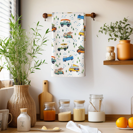 Decorative towel with vehicle pattern hanging on a wooden rack in a kitchen setting.