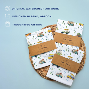 Set of tea towels with vehicle pattern on a woven tray against a light blue background