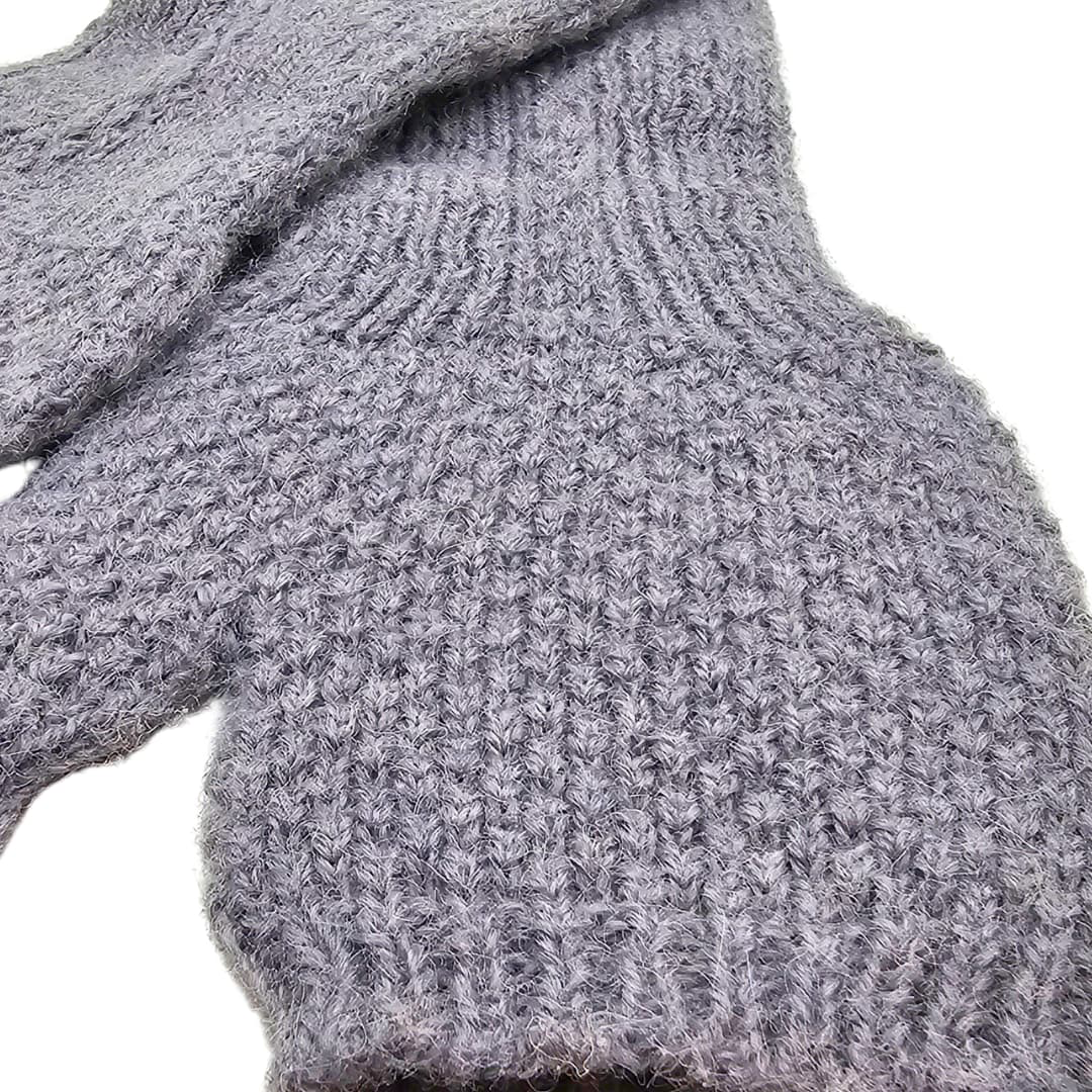 Close-up of a gray knitted fingerless glove on a white background