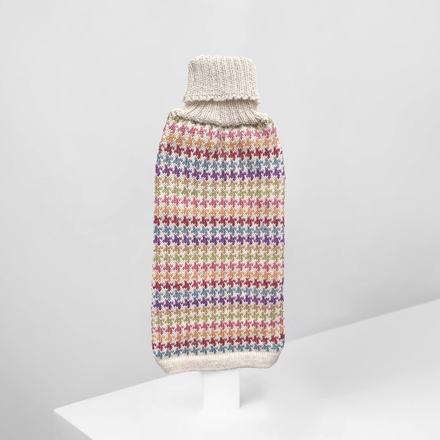 A multicolored alpaca dog sweater with a geometric pattern, displayed on a white stand against a white background.
