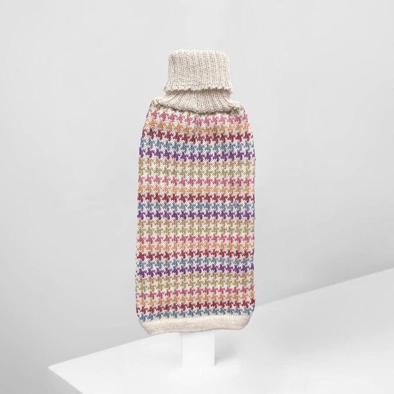 A multicolored alpaca dog sweater with a geometric pattern, displayed on a white stand against a white background.