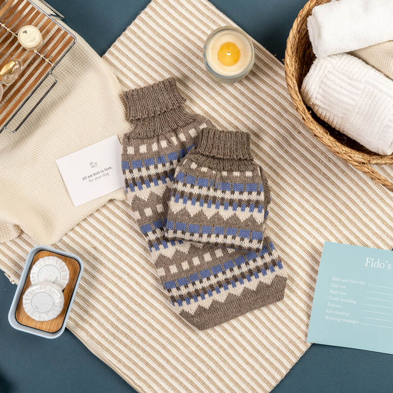 Blue and Beige geometric patterned dog sweaters on spa table