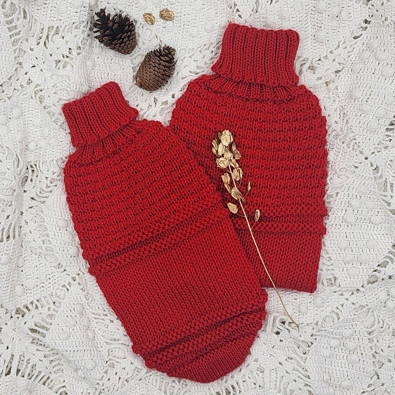 Red textured knit dog sweaters against a white surface