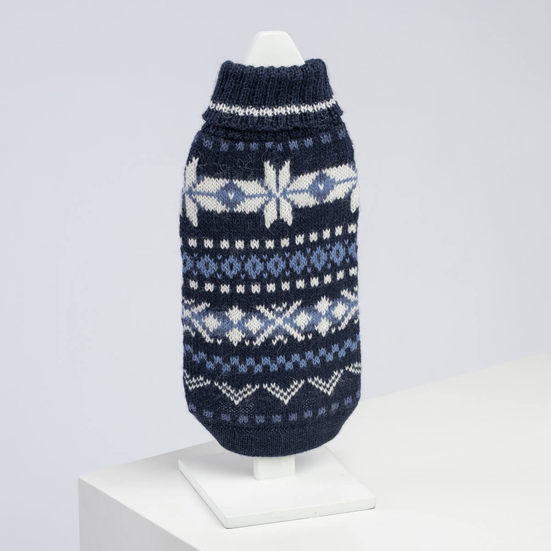 Navy blue knitted dog sweater with white and light blue patterns on a white background