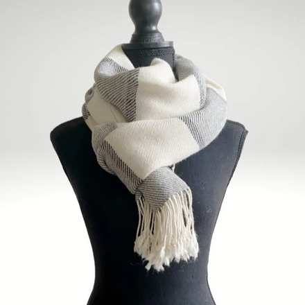 Striped scarf draped over a black mannequin against a white background
