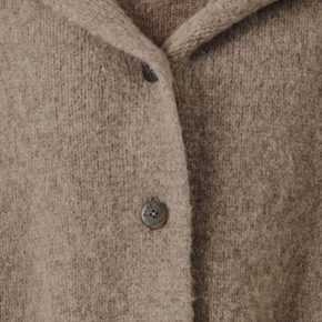 Close-up of a beige knit boat with a button