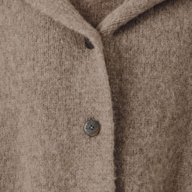 Close-up of a beige knit boat with a button