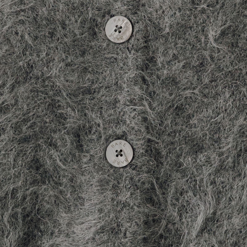 Close-up of a textured gray knit cardigan with two buttons.