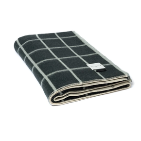 Folded checkered blanket with a visible brand label on a white background