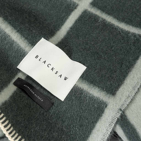 Blacksaw label on a plaid blanket background