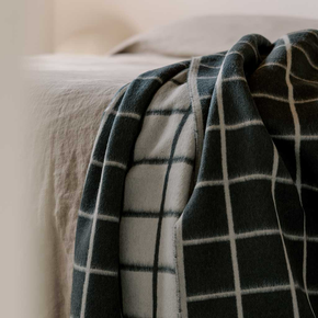 Plaid blanket draped over a surface with a neutral background