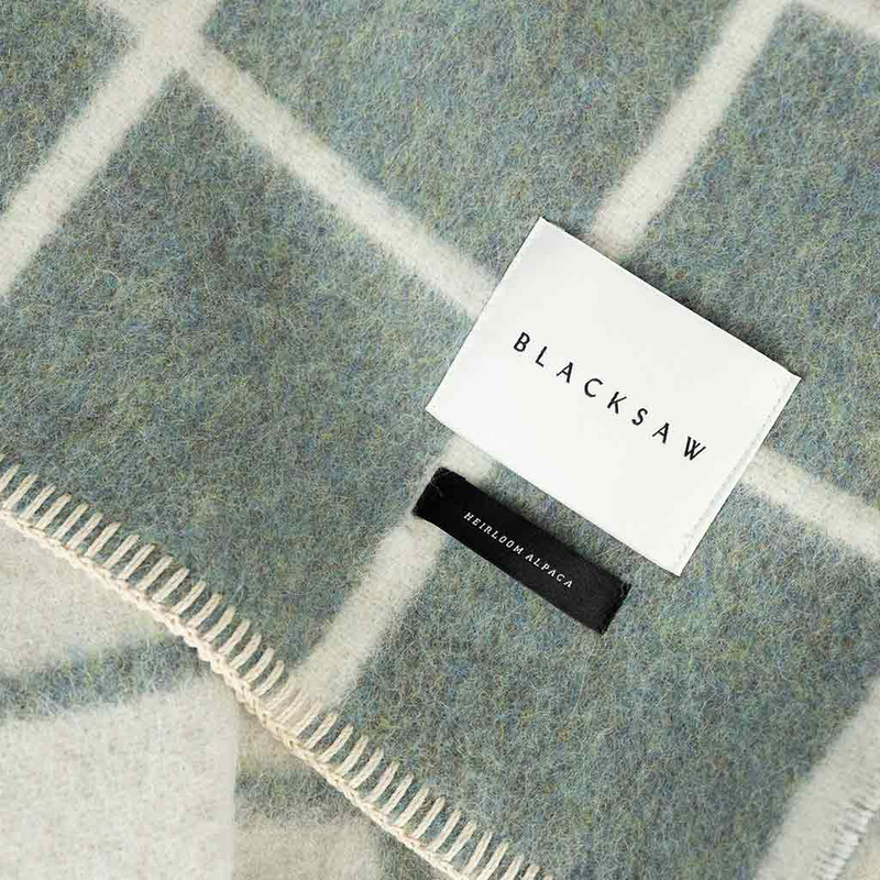 Plaid blanket with 'BLACKSAW' label on a checkered pattern
