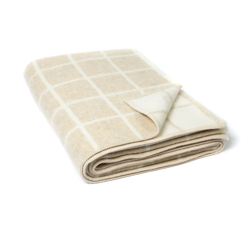Folded beige blanket with a grid pattern on a white background