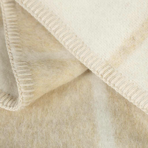 Close-up of a textured beige blanket with a ribbed edge