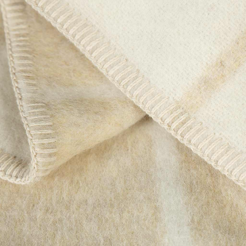 Close-up of a textured beige blanket with a ribbed edge