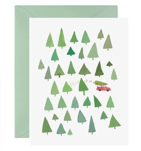 Greeting card with green trees and a red car on a white background