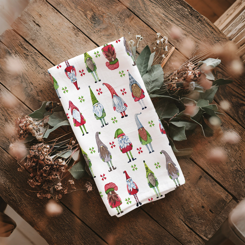 Tea towel with gnome pattern on a wooden surface with dried plants