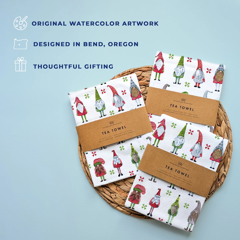 Set of tea towels with gnome design on a woven basket against a light blue background.