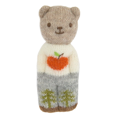 Knitted bear toy with a white shirt, orange heart, and gray pants on a white background