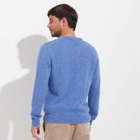 Man wearing a blue sweater against a white background