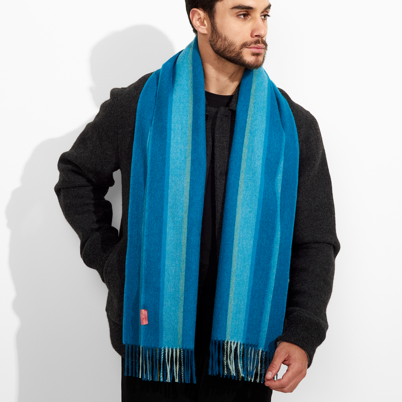 Man wearing a blue striped scarf against a white background
