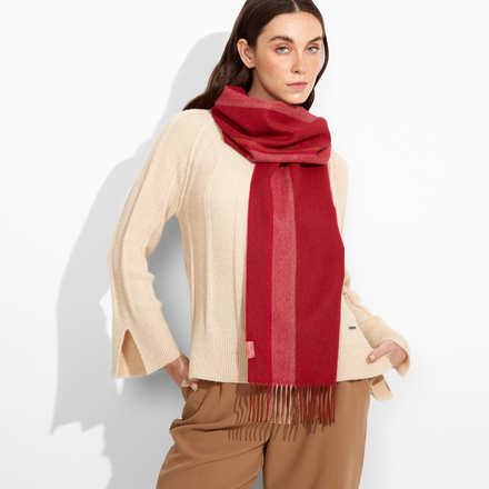 Woman wearing a red scarf and beige outfit on a white background