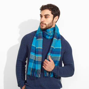 Man wearing a blue sweater and plaid scarf on a white background