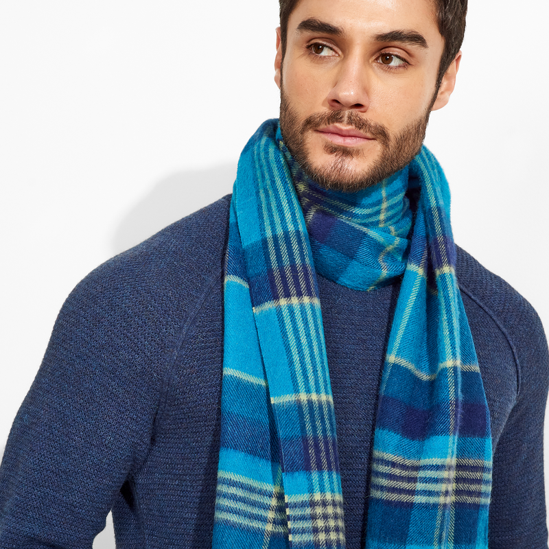 Man wearing a blue plaid scarf against a white background