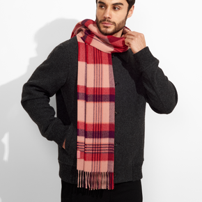 Man wearing a red and pink plaid scarf against a white background